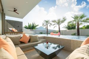 a living room with a couch and a glass table at Capucine Villas in Kamala Beach
