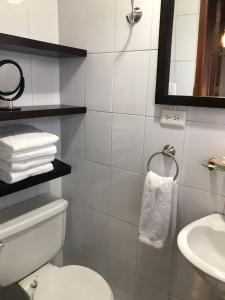 a bathroom with a white toilet and a sink at Hotel Colonial San Agustin in Quito +116 photos