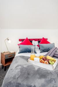 a tray of food on a bed with orange juice at Stunning 2-Bed Apt - Free Parking - Gated Hideaway - Watford Gen Hospital - Watford FC - Shopping - Atria in Watford