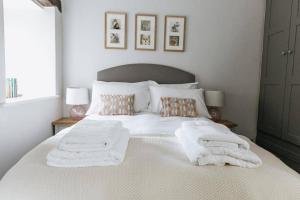 - une chambre avec un lit blanc et des serviettes dans l'établissement GABLE COTTAGE - One Bed Cottage Close to Holmfirth and the Peak District, à Hepworth