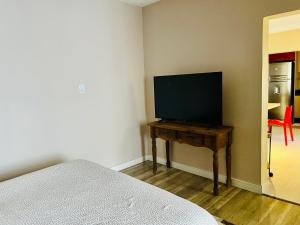 um quarto com uma televisão de ecrã plano sobre uma mesa em Flat Blumenau Vila Nova em Blumenau