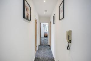 a hallway with white walls and a phone on a wall at Stunning 2-Bed Apt - Free Parking - Gated Hideaway - Watford Gen Hospital - Watford FC - Shopping - Atria in Watford