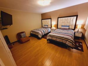 a bedroom with two beds and a flat screen tv at Miraflores Dpto 2 dorm. espaciosos 4 huéspedes 90m2 in Lima