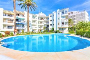 a large swimming pool in front of some apartment buildings at Las Palmeras 3, Nerja in Nerja