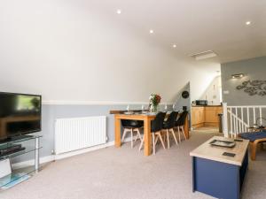 a living room with a table and chairs and a television at Valley Lodge 52 in Callington