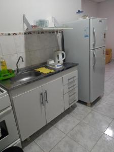 eine Küche mit einer Spüle und einem Kühlschrank in der Unterkunft Apart Belgrano in Corrientes