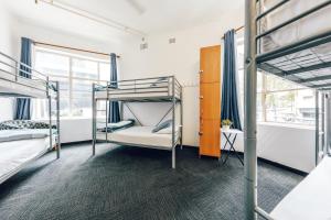 a dorm room with bunk beds and a window at Maze Backpackers - Sydney in Sydney