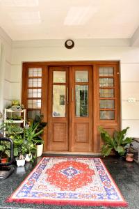 a front door with a rug in front of it at Kannur Beachway Homestay in Pāppinisseri