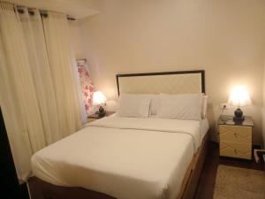 Apartment in Porto Sharm VIP في شرم الشيخ: غرفة نوم بسرير ابيض كبير ومصباحين