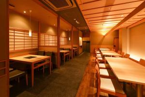 a row of tables and benches in a restaurant at HOTEL MYSTAYS Kyoto Shijo in Kyoto