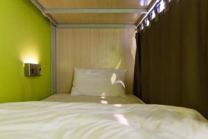 un letto in una camera con parete verde di Siamaze Hostel a Bangkok