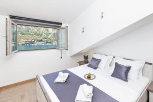 een slaapkamer met een groot wit bed met een raam bij De Lux Apartments Sirena in Kotor +110 foto's