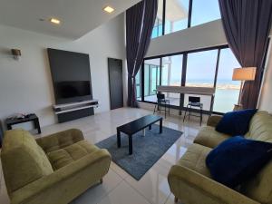 a living room with two couches and a television at Sunrise Gurney Premium Executive City/Seafront suite - Penang in George Town