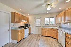 a kitchen with wooden cabinets and a ceiling fan at Cozy Villas Cottage with Deck, half Block to Beach! in Villas
