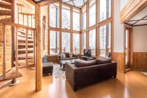 a living room with a couch and some windows at Midori House - walking distance to Rusutsu Resort in Rusutsu