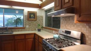 una cucina con piano cottura, lavandino e finestra di GUEST HOUSE IN HILO a Hilo