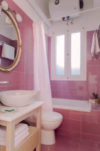 a pink bathroom with a sink and a toilet at Casa di Mema in Argostoli