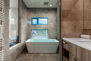 bagno con vasca e lavandino di Off Piste Chalet by H2 Life a Kutchan