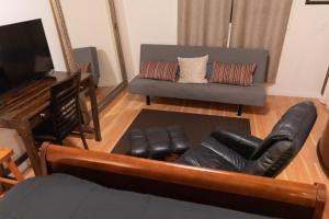 a living room with a couch and a television at Cozy private Guest House in Los Angeles
