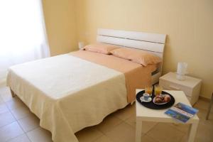 a bedroom with a bed and a tray of food on a table at Sant'Alfonso Rooms in Marina di Camerota