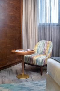 a chair and a table in a room at Ascott Corniche Al Khobar in Al Khobar