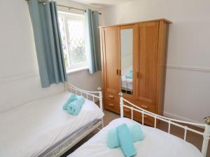 ein Schlafzimmer mit 2 Betten und einem Medizinschrank in der Unterkunft Grooms Cottage in Tenby + 17 Fotos