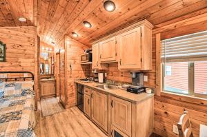 een keuken met houten kasten en een bed in een huisje bij Beautiful New Bern Studio Cabin with Fire Pit! in New Bern