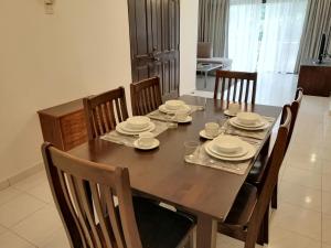 mesa de madera con sillas y comedor en Noble Villa Apartment, en George Town