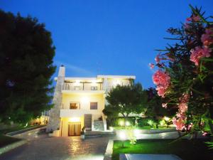 un gran edificio blanco por la noche con luces en Villa Dafne, en Bari