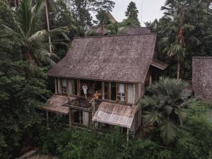 
a small hut with a couple of people sitting on it at Blue Karma Dijiwa Ubud in Ubud
