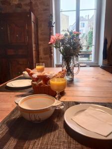 a table with a bowl of bread and two glasses of orange juice at Chambrecosy salle de bain privée in Quimper