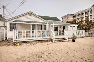 a small white house with a porch and a house at Cozy Hampton Cottage with BBQ - Walk to Ocean! in Hampton