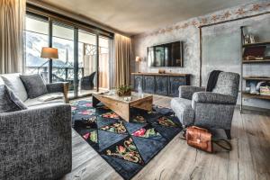 a living room with two chairs and a fireplace at Valsana Ferienwohnungen Arosa in Arosa