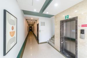 a hallway with an elevator in a building at Olive Rest House Road by Embassy Group in Bangalore