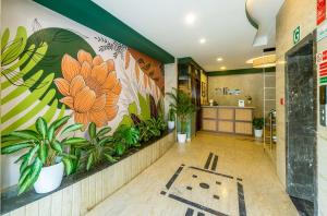 a lobby with a mural of plants on the wall at Olive Rest House Road by Embassy Group in Bangalore