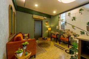 Olive Rest House Road by Embassy Group في بانغالور: غرفة معيشة مليئة بالكثير من النباتات