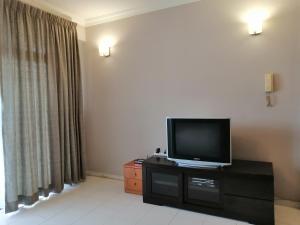 a living room with a flat screen tv on a dresser at Noble Villa Apartment in George Town