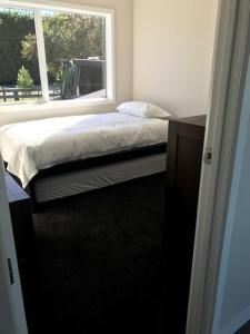 een slaapkamer met een bed en een raam bij Dunray Cottage - Welcome to Havelock North in Hastings