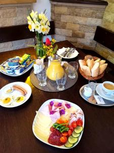 una mesa de madera con platos de comida. en Excalibur Penzion a Restaurace en Moravská Třebová