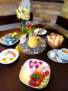 une table en bois avec des assiettes de nourriture dans l'établissement Excalibur Penzion a Restaurace, à Moravská Třebová