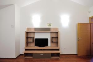 TV en un centro de entretenimiento de madera en una habitación en Apartments Old Bridge, en Mostar