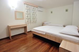 Un dormitorio con una cama grande y suelo de madera. en Apartments Old Bridge, en Mostar