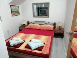 Un dormitorio con una cama roja con dos toallas encima. en Villa Dore, en Škrip 41 fotos más