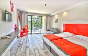 a bedroom with a bed and a desk and a chair at GRIFID Hotel Foresta - All Inclusive & Free GRIFID Beach - Adults Only in Golden Sands