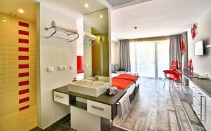 a bathroom with a sink and a mirror and a couch at Grifid Hotel Foresta - All Inclusive & Free Parking - Adults Only in Golden Sands