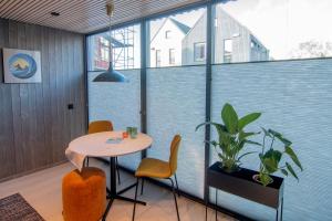 balcón con mesa, sillas y maceta en Været - Your Lofoten Basecamp, en Henningsvaer