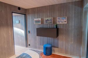 Zimmer mit Holzwänden und einem blauen Stuhl in der Unterkunft Været - Your Lofoten Basecamp in Henningsvær