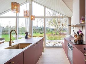 a kitchen with a sink and a large window at Holiday home Væggerløse CCX in Marielyst