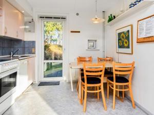 a kitchen with a wooden table and chairs at 6 person holiday home in Rømø-By Traum in Sønderby
