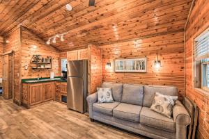 a living room with a couch and a refrigerator at Charming New Bern Log Cabin - Pets Welcome! in New Bern